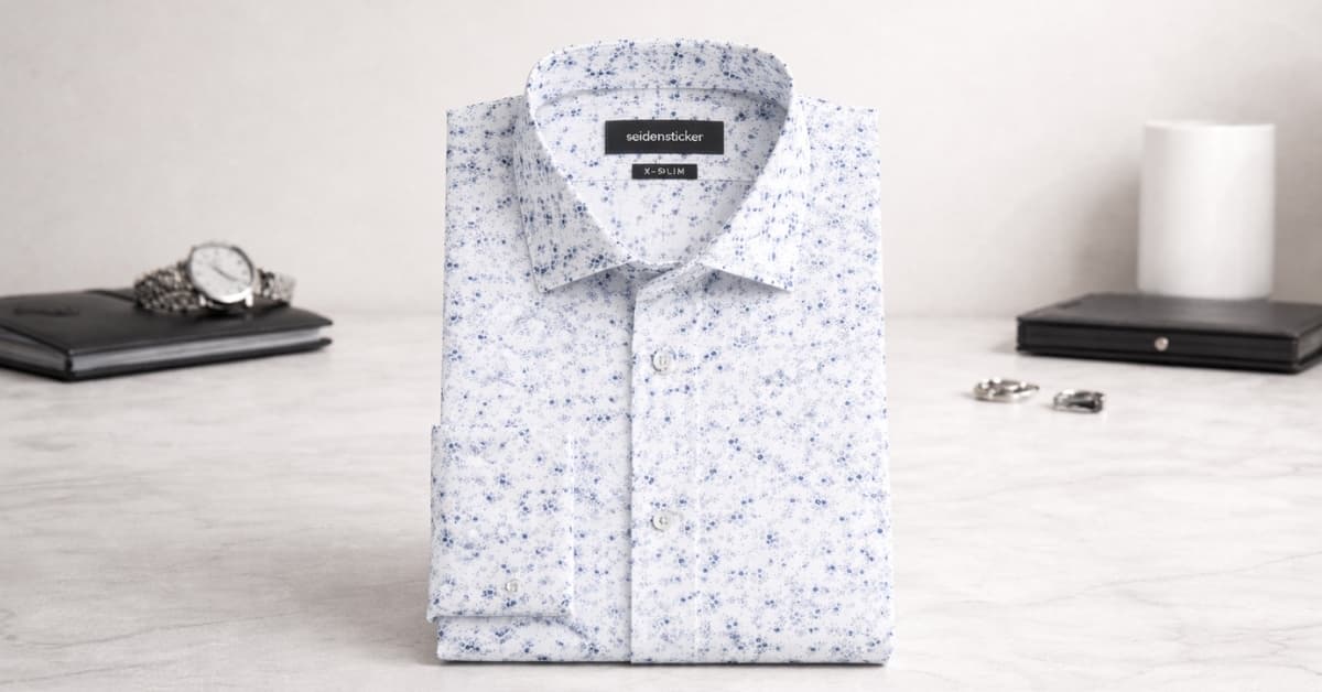 Seidensticker X-Slim Business Hemd Druck with light blue printed pattern, folded dress shirt on modern desk background