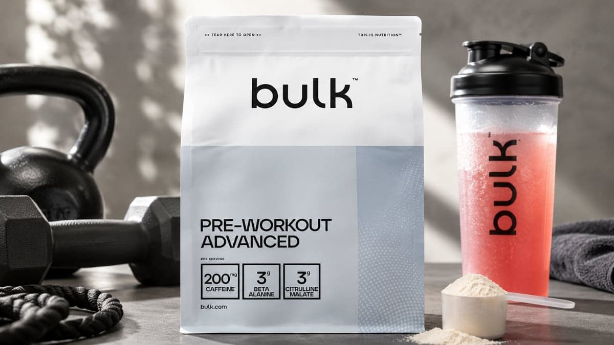 "Bulk Pre-Workout Advanced powder container with scoop beside mixed pre-workout drink, highlighting a high-stimulant workout supplement for energy, endurance, strength, and focus."