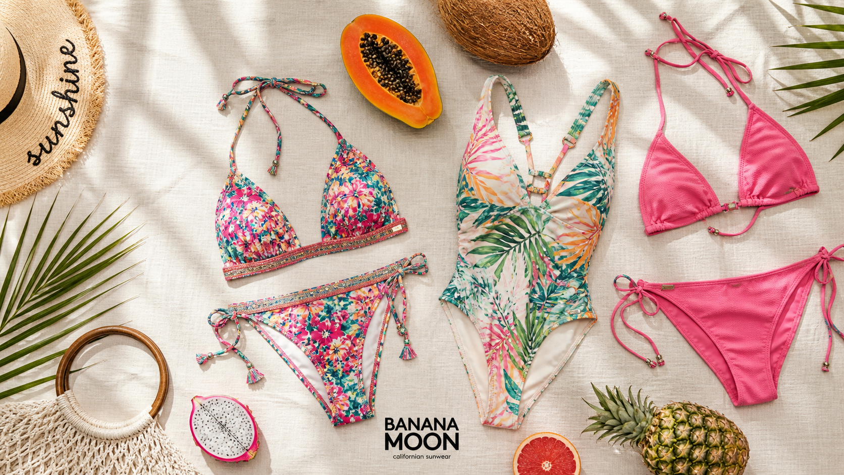 Colorful Banana Moon swimsuit collection displayed on sandy beach with ocean waves